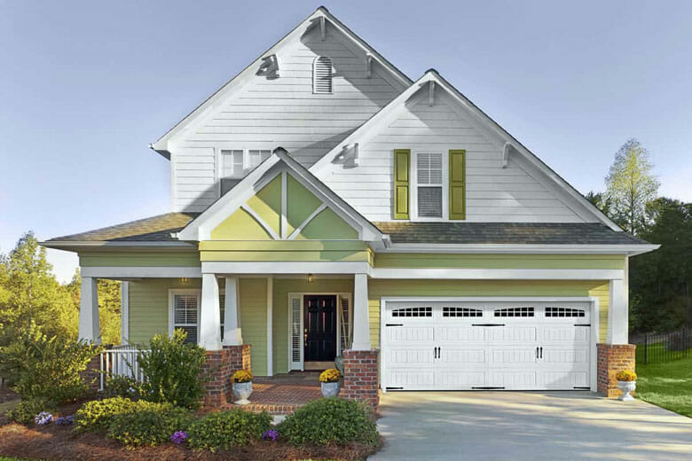 Green house with a bead board panel garage door